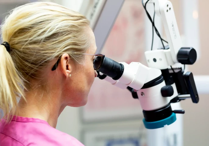 Tannlege ved mikroskop hos Torshov Tannklinikk